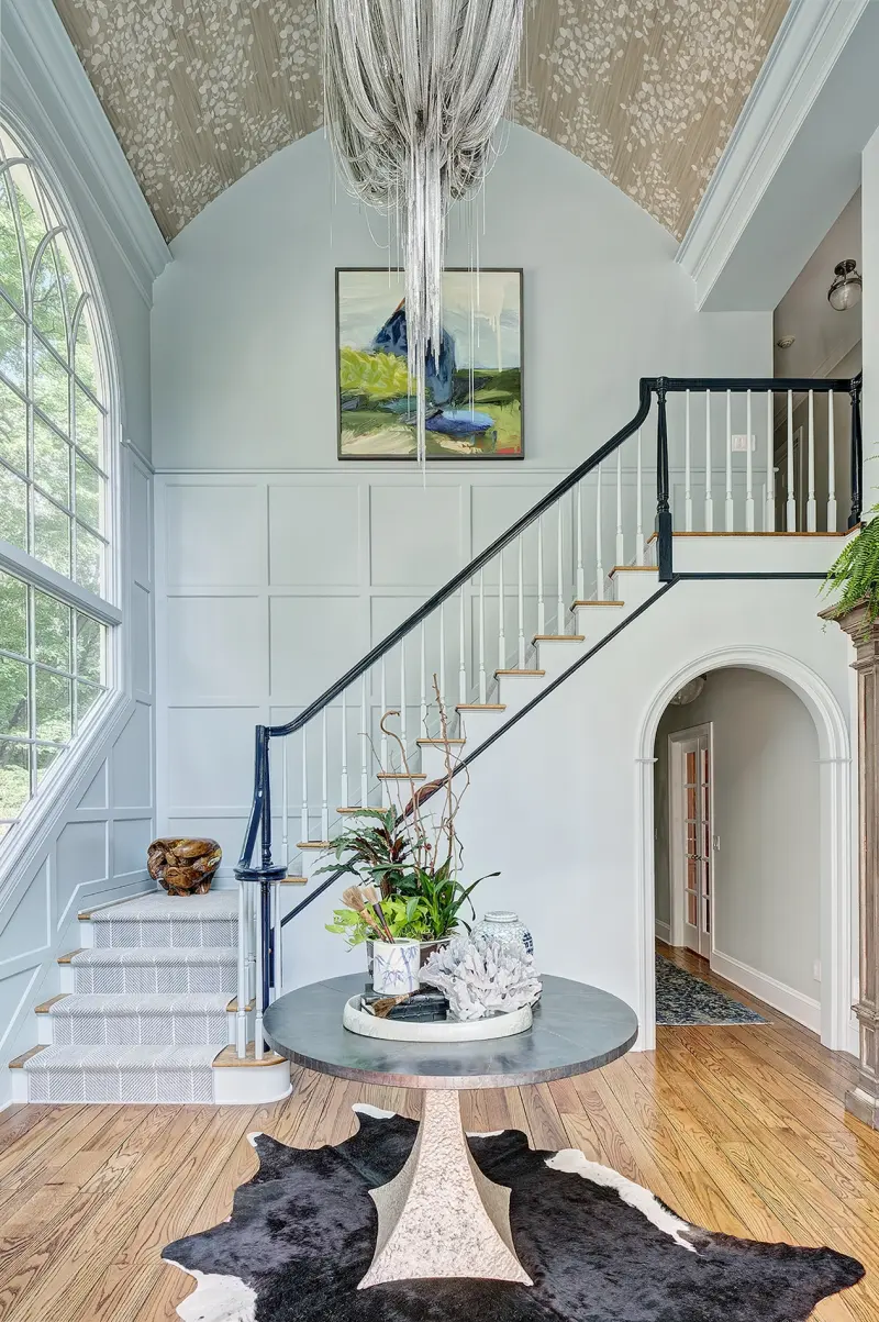 Two-storey foyer with a panelled stair and a woven Greek key stair runner, designed by Beth Krupa Interiors
