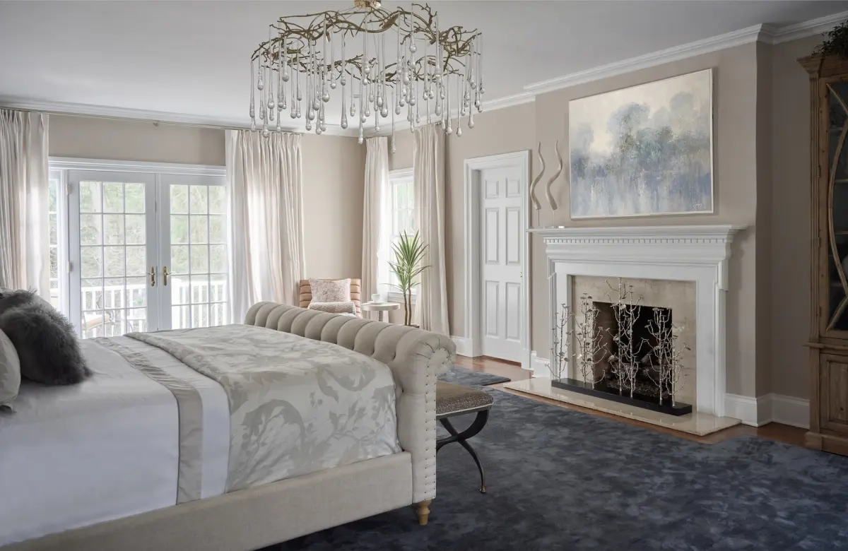Primary bedroom in New Canaan, Connecticut with a branch chandelier and a pale blue rug, by Beth Krupa Interiors