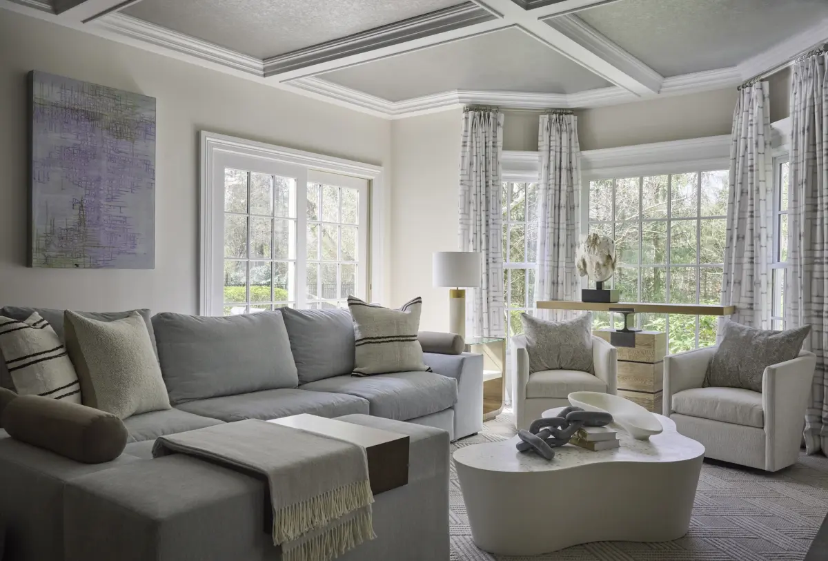 Living room with a coffered ceiling and layered neutral seating in a New Canaan, Connecticut home designed by Beth Krupa Interiors